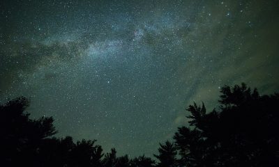 夜晚走廊尽头门口的剪影画面，室内灯光昏黄，人物停步的瞬间充满张力